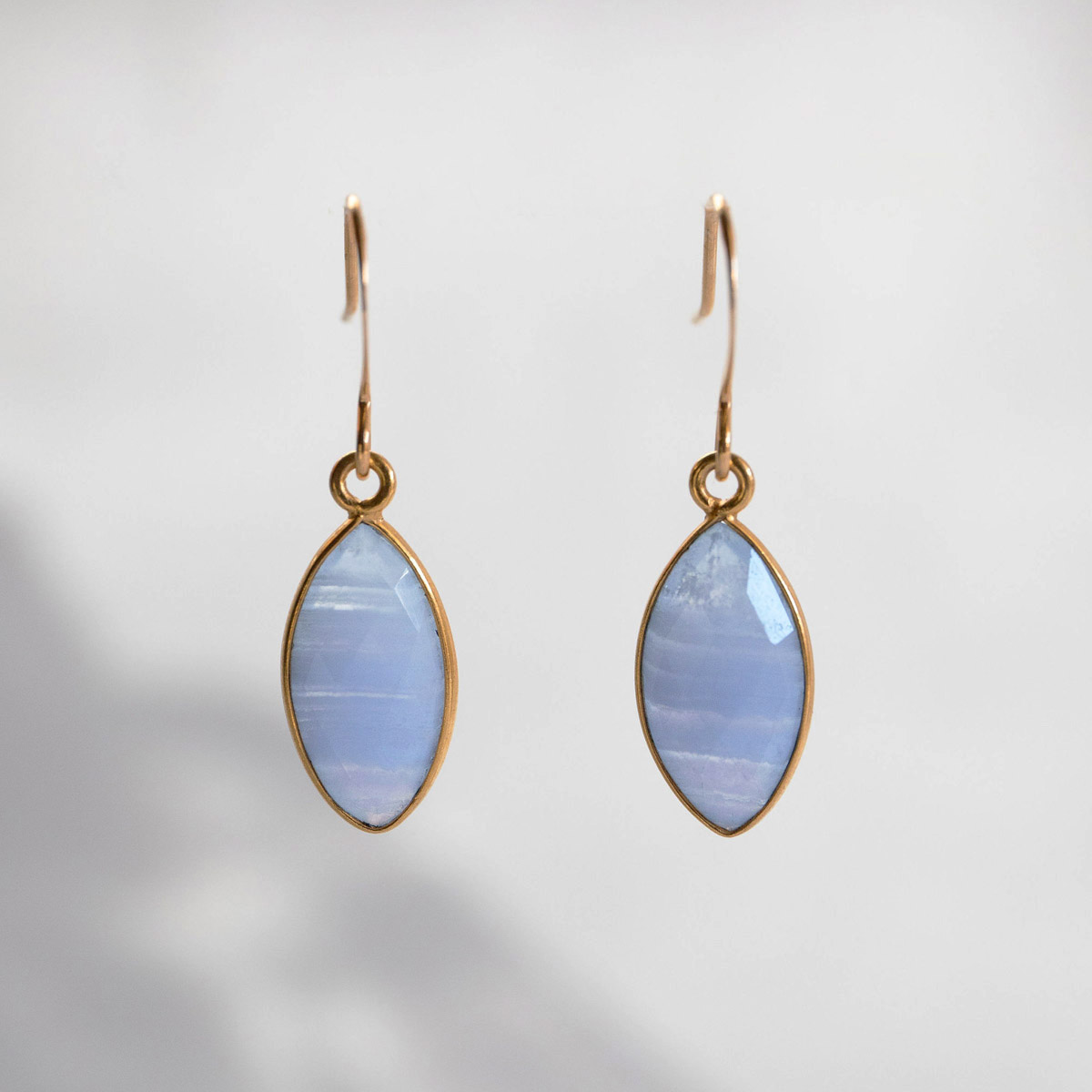 The Endless Sky Earrings, bezel-set marquise cut blue lace agates finished on gold tone french style hooks.
